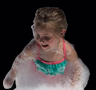 inset-girl-masked A young girl in a green and pink swimsuit smiles and plays, covered in bubbles, against a black background.