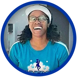 staffer A person wearing glasses, a white visor, and a blue shirt with a unicorn logo is smiling widely. The image is framed by a blue circular border.